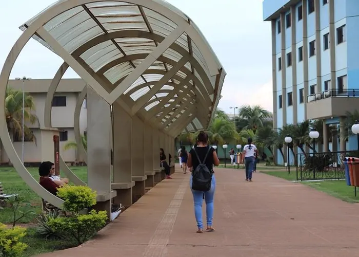 Passarela coberta do campus com estudantes circulando
